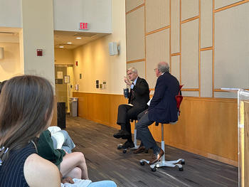 Sen. Bill Cassidy and Steven Pearlstein sit on stools in front of an audience in a room at Fenwick Library