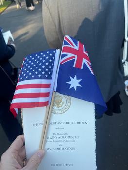 A small U.S. flag and an Australian flag adorn a program from an event at the White House.